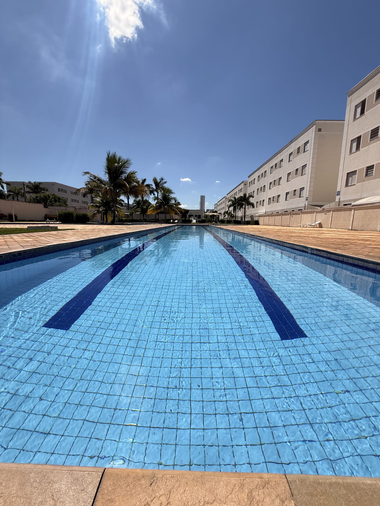 Piscina raia comprida com prédios ao lado